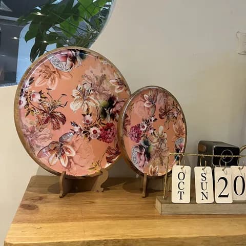 Pink floral ceramic plates on a wooden stand