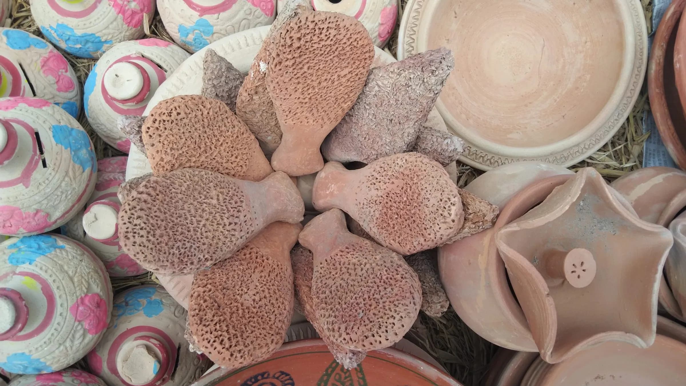 Hand-painted clay pots and pressed terracotta dishes, seen from above