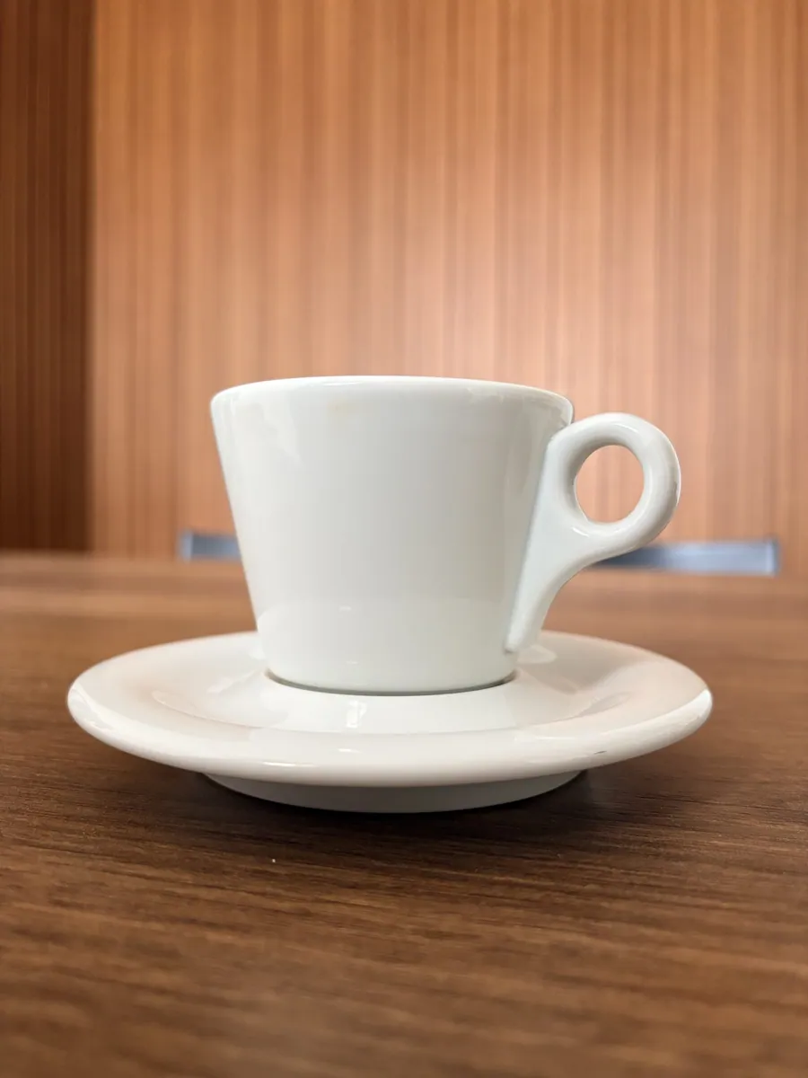 White ceramic cup and saucer on a wooden table