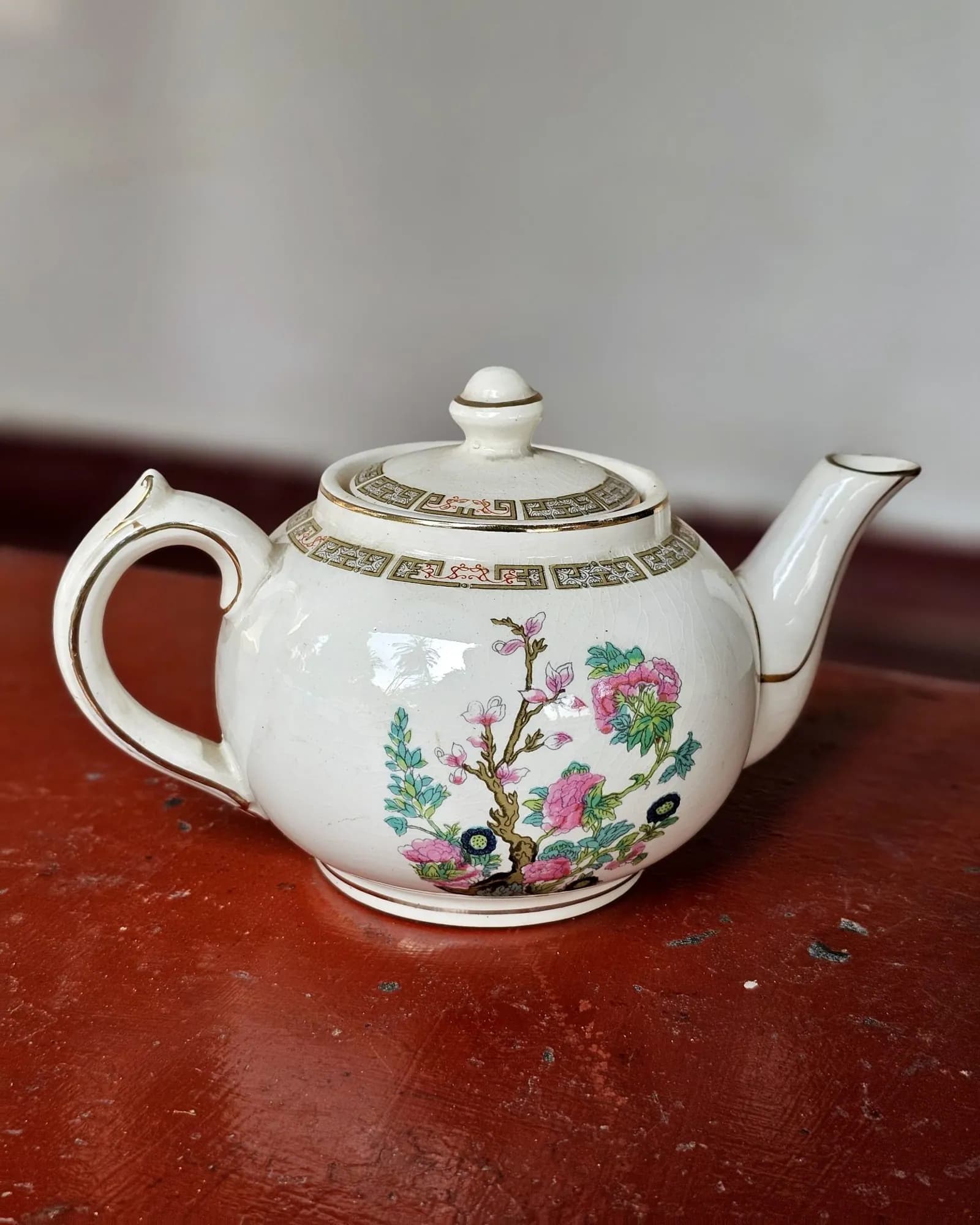 White ceramic teapot with a floral pattern