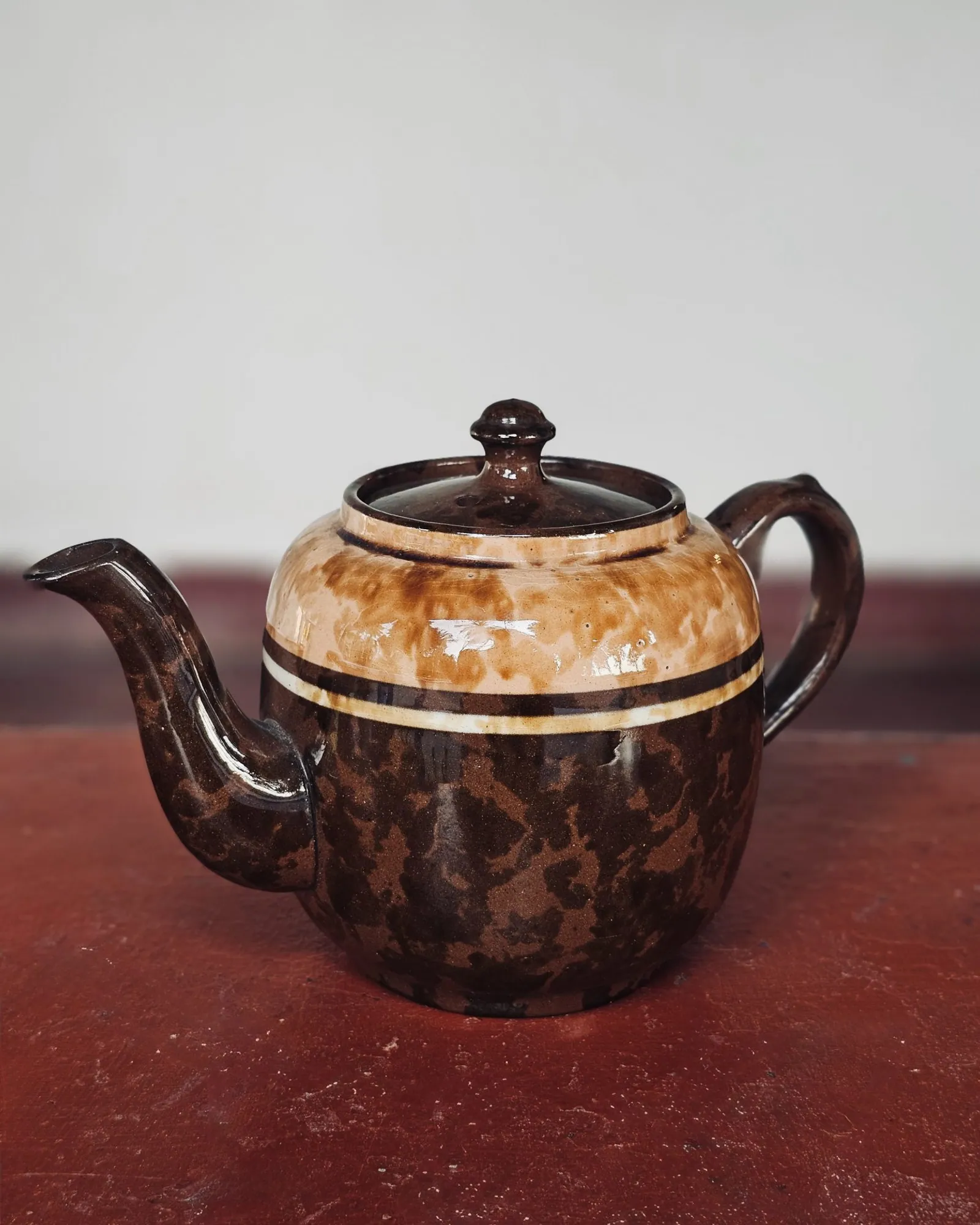 Brown glazed ceramic teapot on a dark table