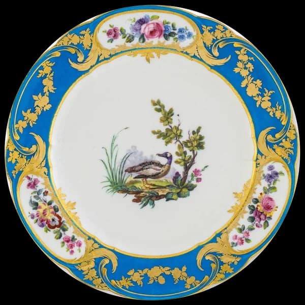 Porcelain plate with a turquoise and gilt border and a bird at the centre