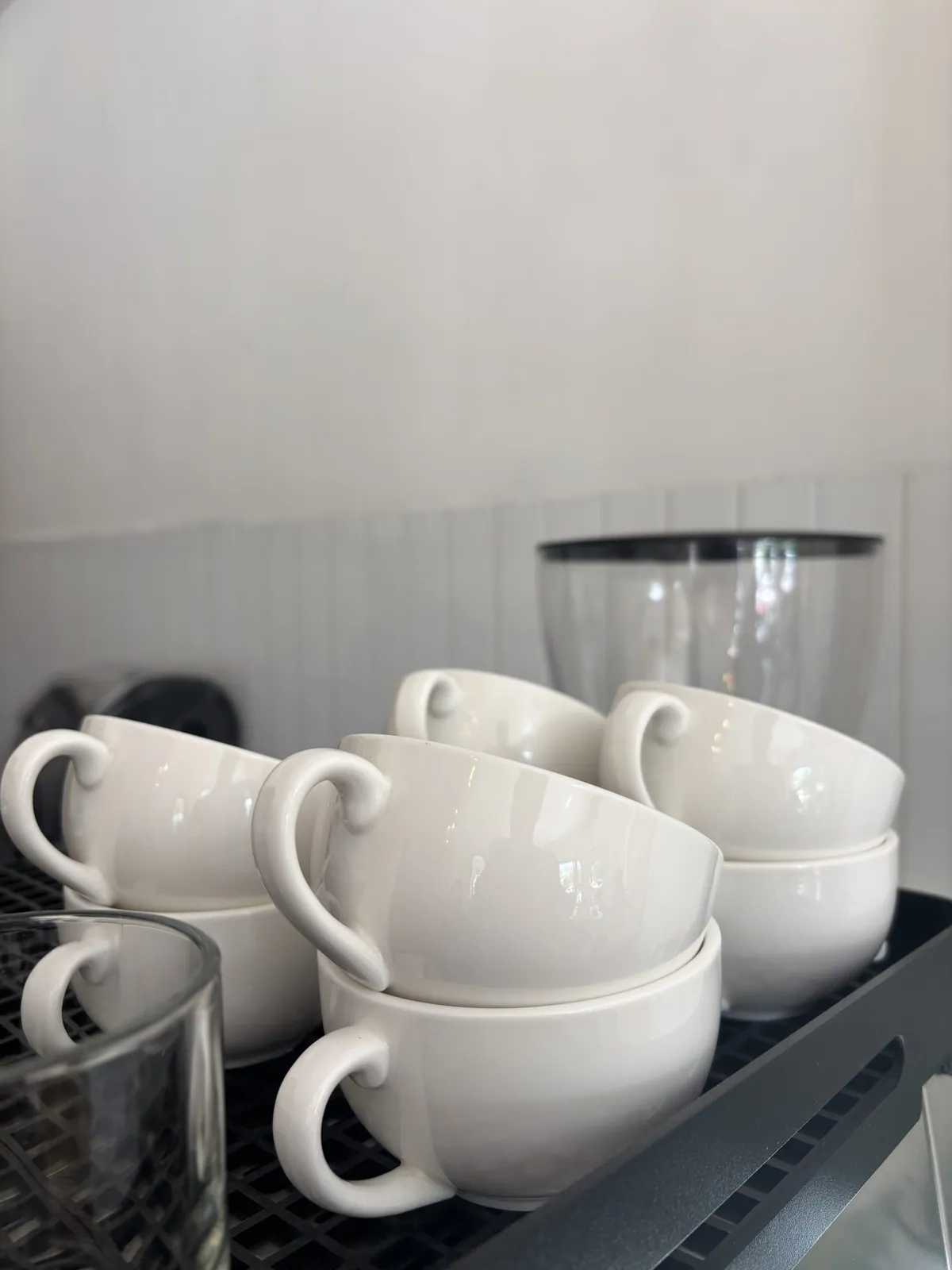 White ceramic cups on a rack